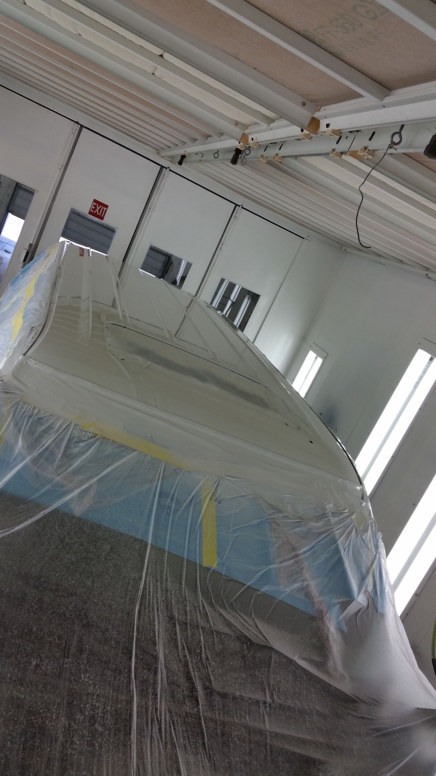 Boat wrapped in plastic in a paint booth.