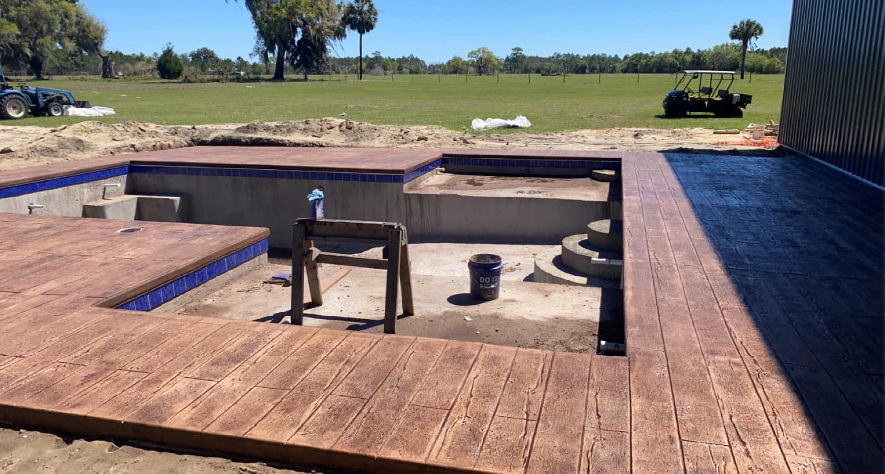 A wooden deck is being built around a swimming pool