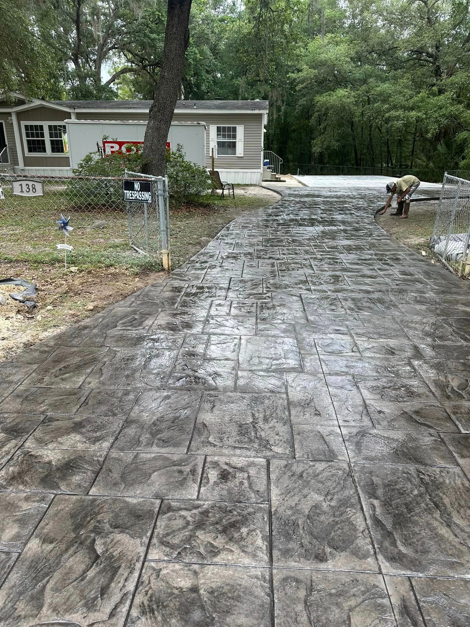 A concrete driveway is being built in front of a mobile home.