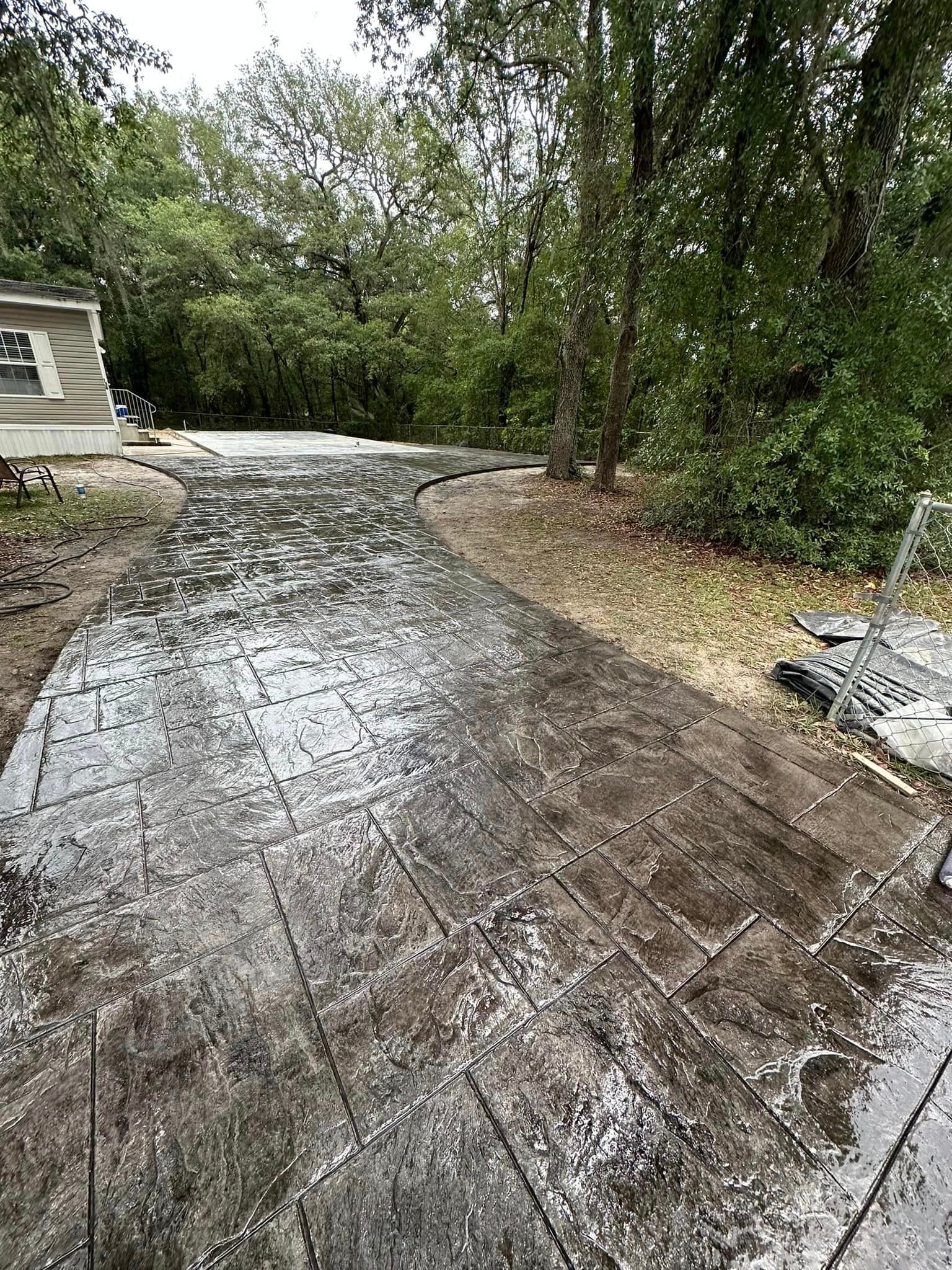 A muddy driveway with trees in the background.