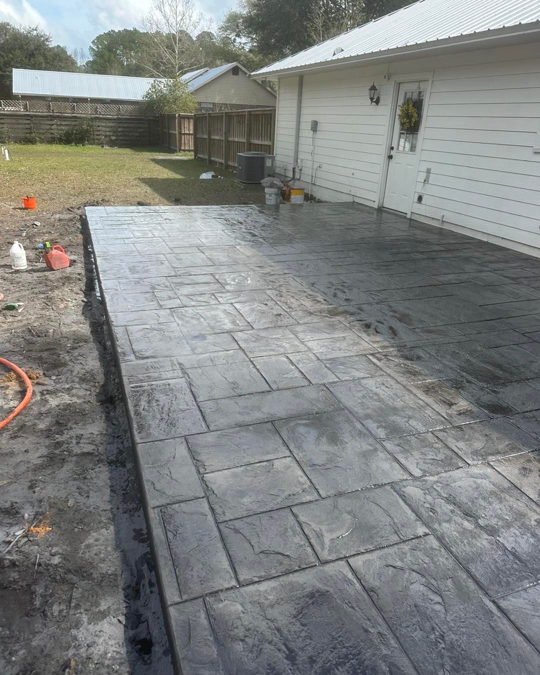A concrete driveway is being built in front of a house.
