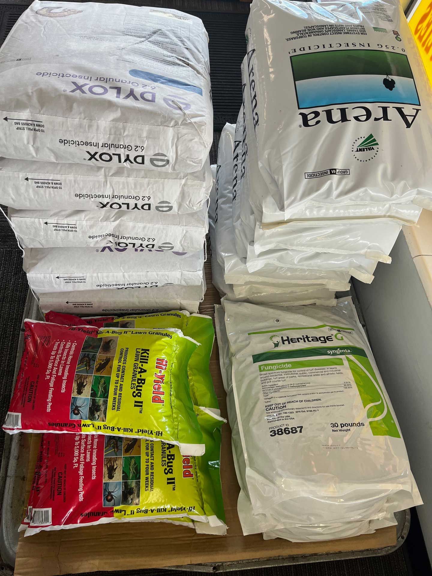 A bunch of bags of fertilizer are stacked on top of each other on a table.