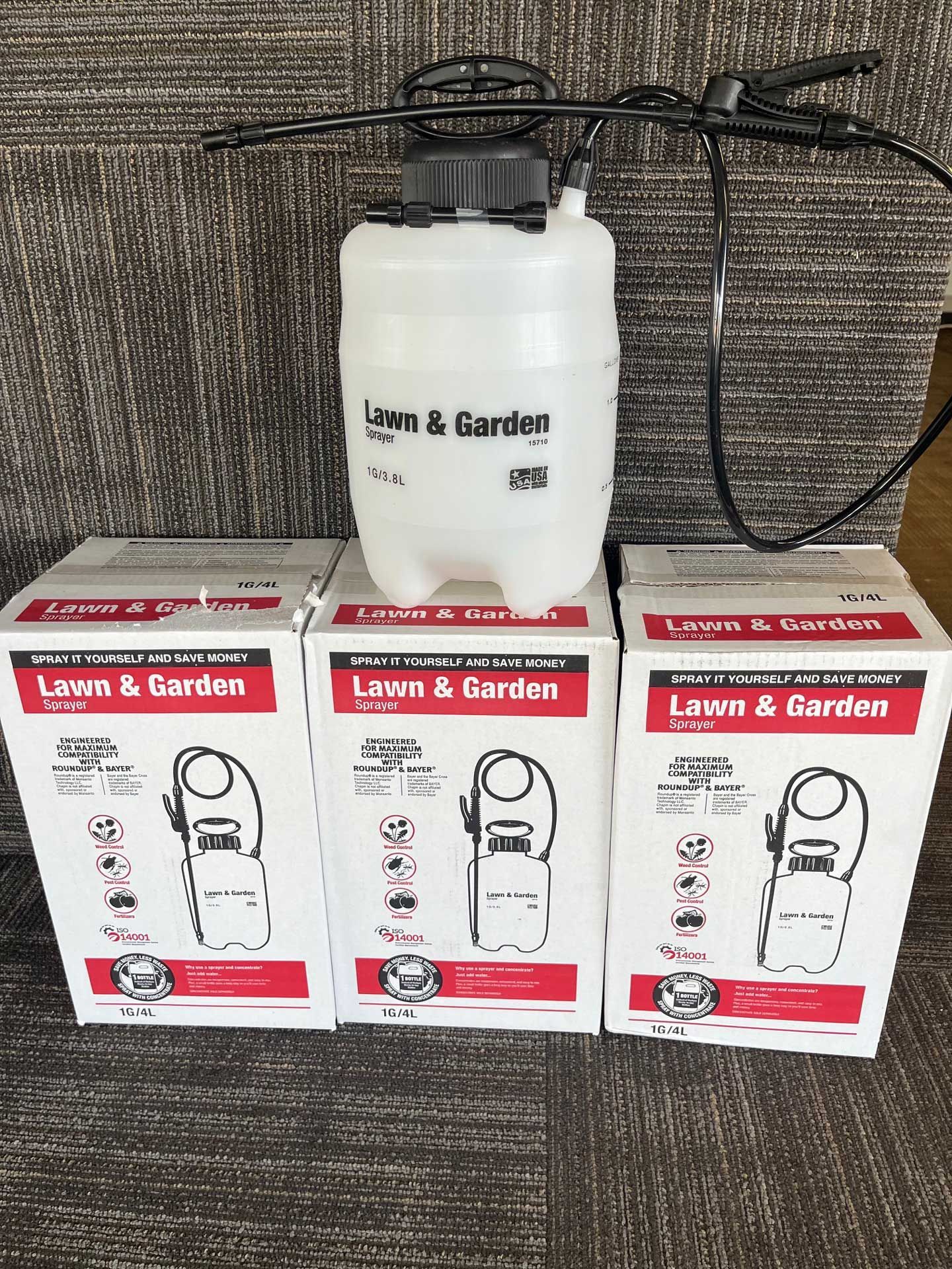 A lawn and garden sprayer is sitting on top of three boxes.