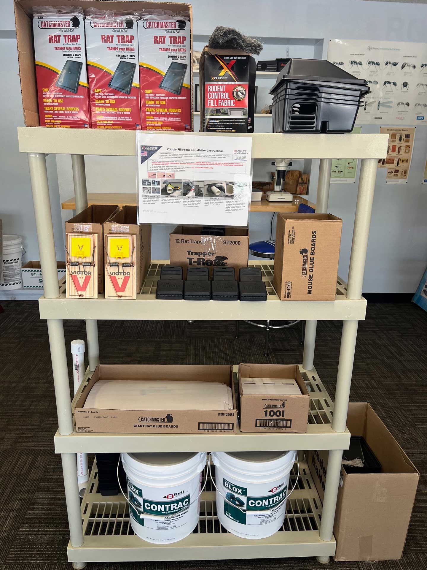 A shelf filled with boxes , buckets , and other items.