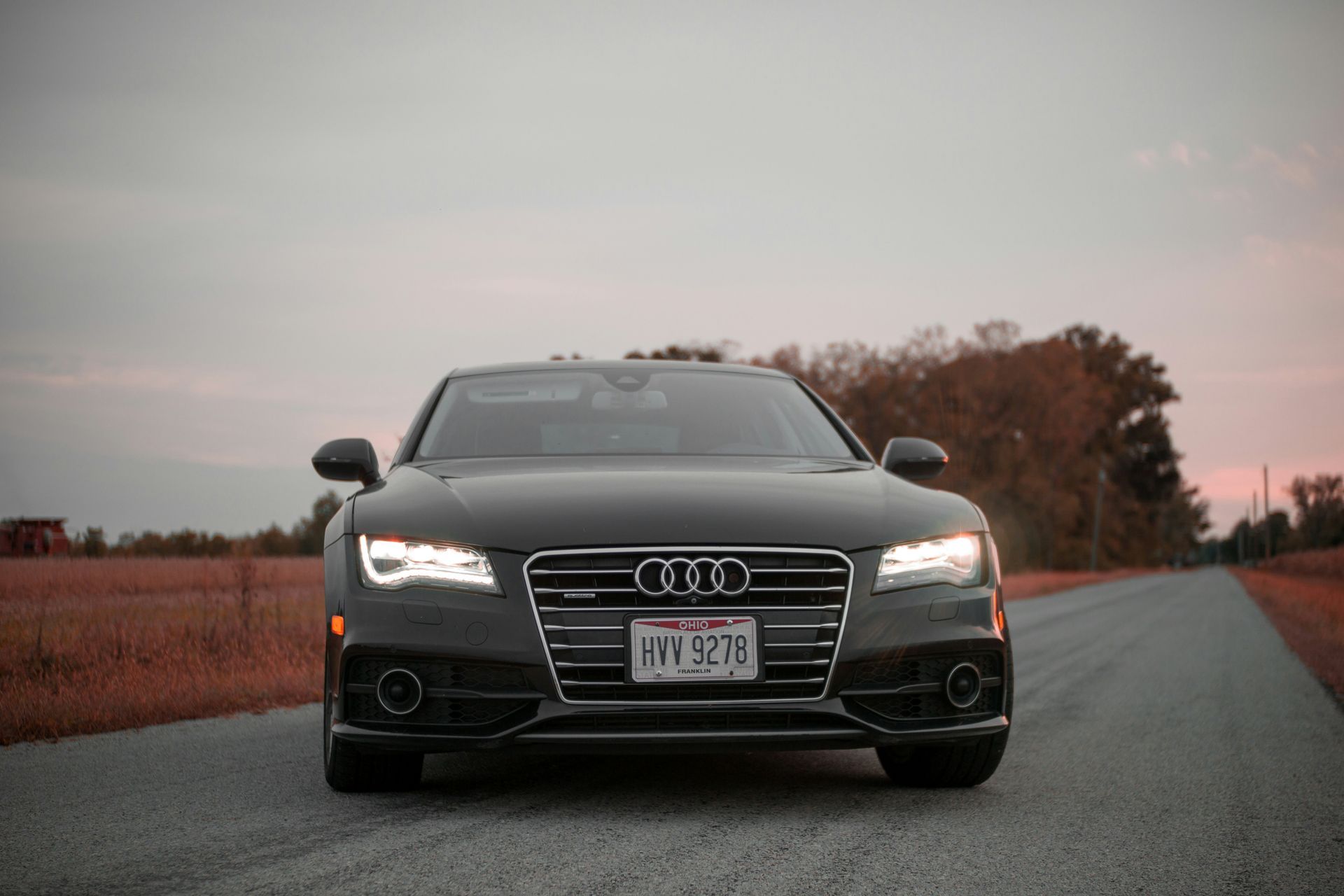 A gray audi is parked on the side of a road.