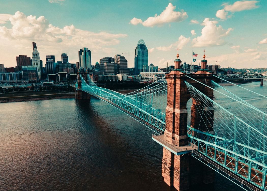 A bridge over a body of water with a city in the background