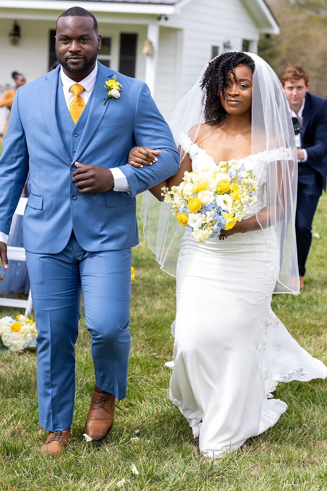A bride and groom are walking down the aisle at their wedding.