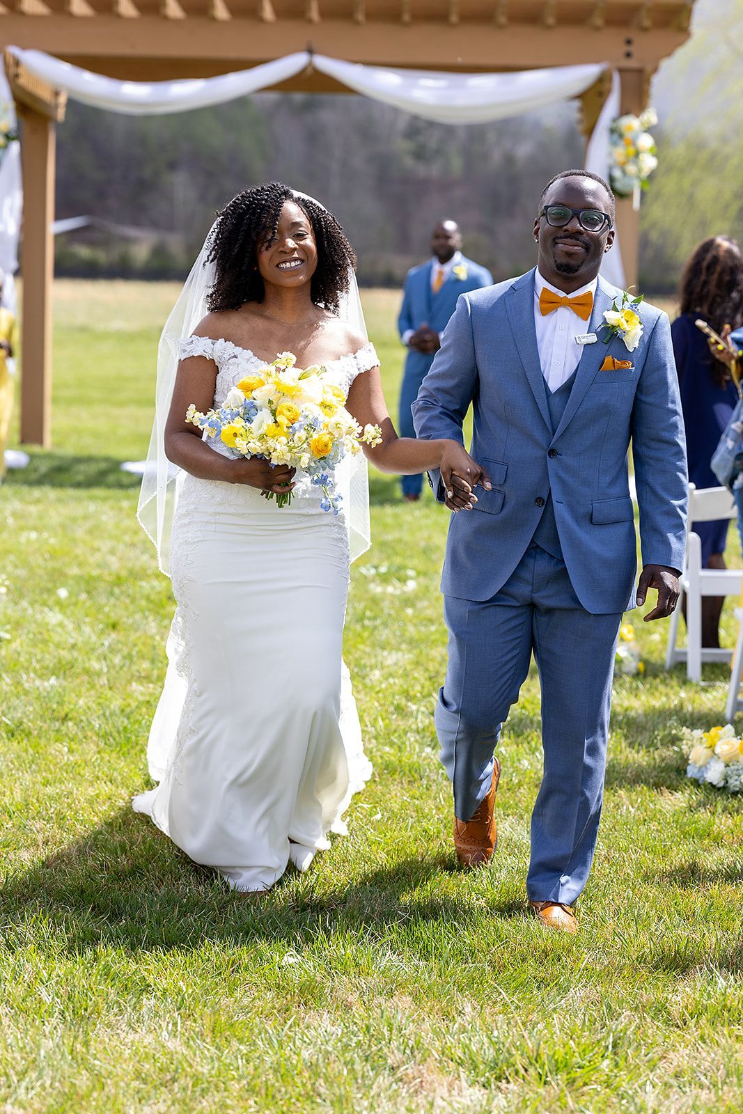 A bride and groom are walking down the aisle at their wedding holding hands.