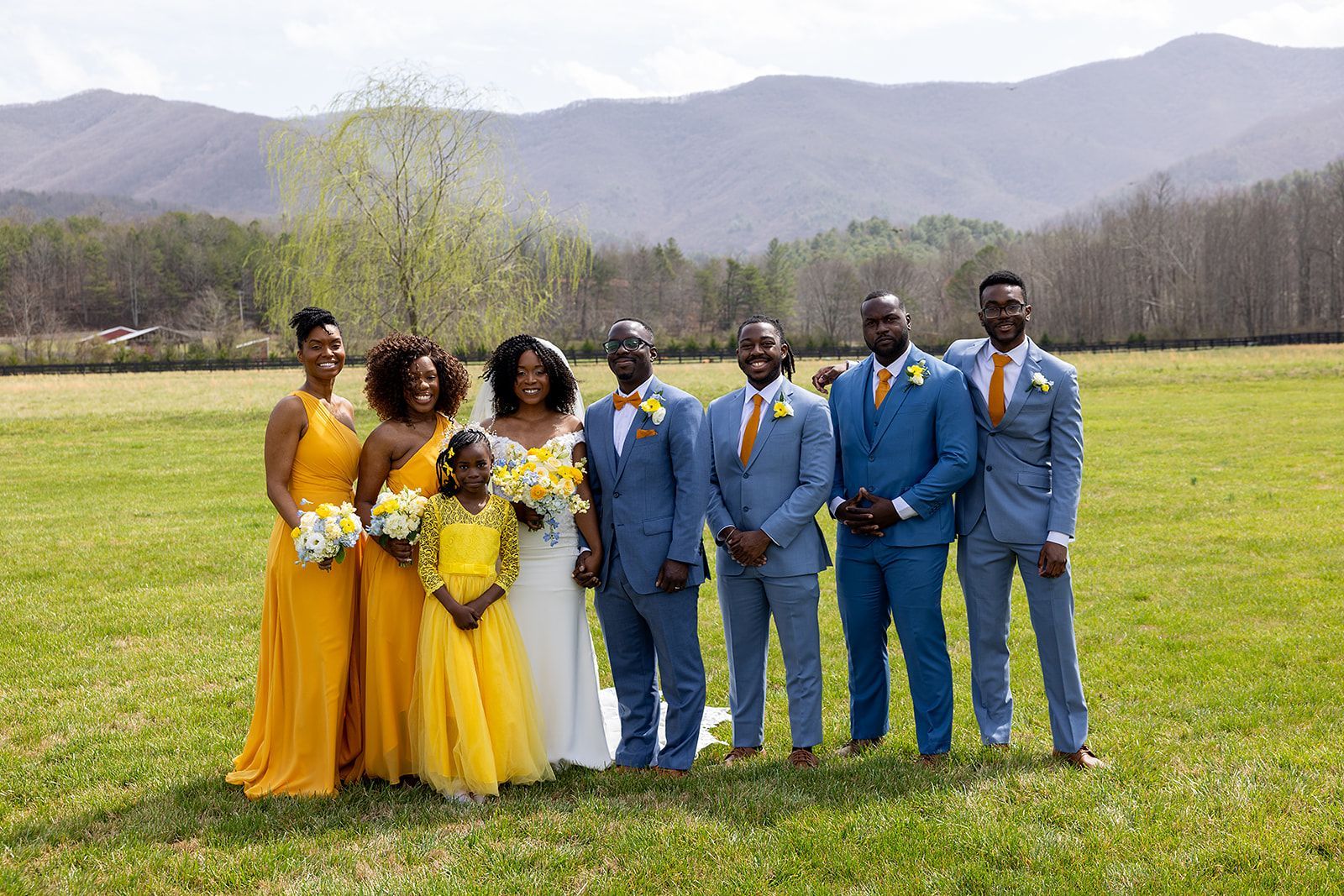 The bride and groom are posing for a picture with their wedding party.