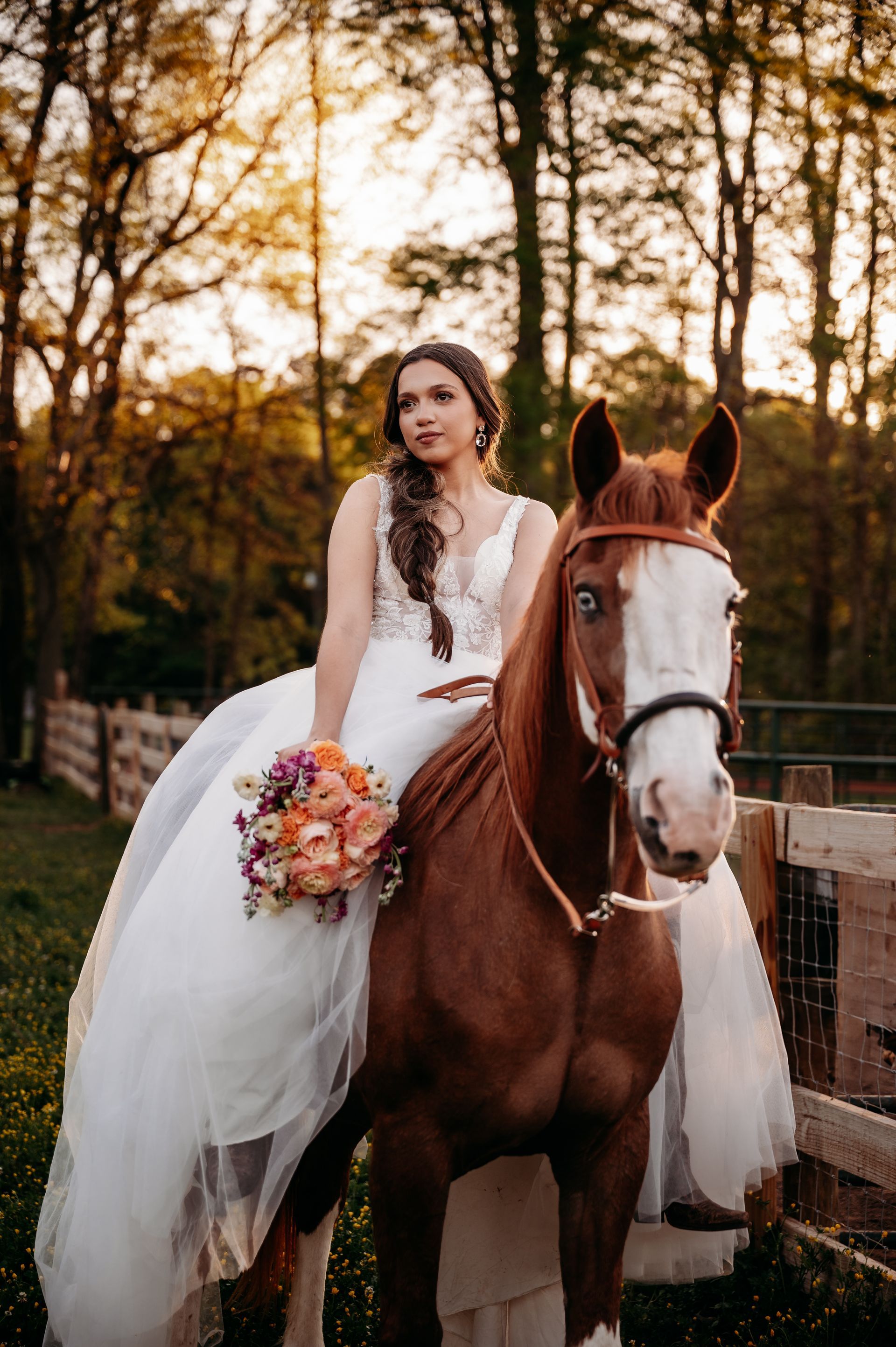 A bride in a wedding dress is riding a brown horse.