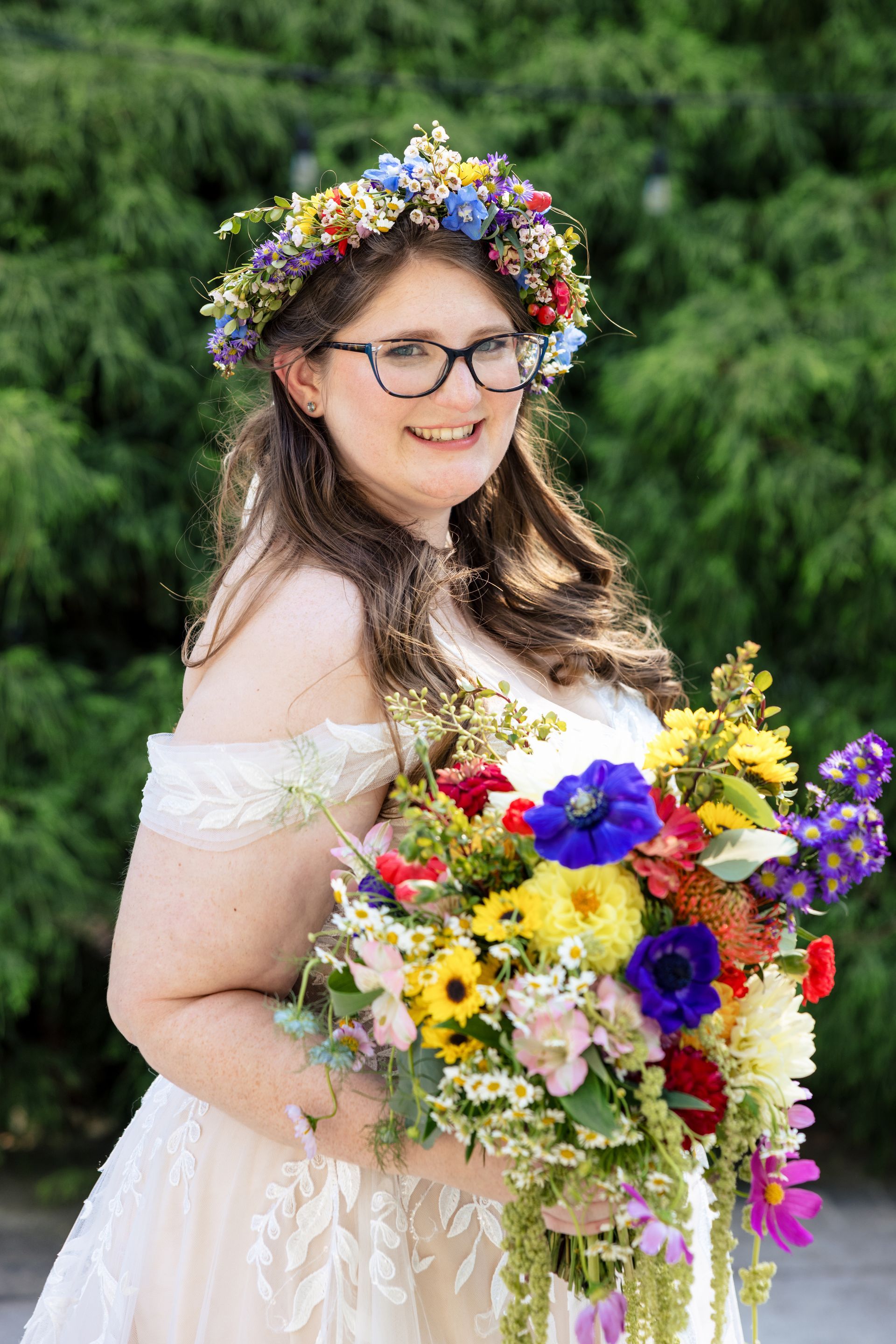 The bride is wearing a flower crown and holding a bouquet of flowers.