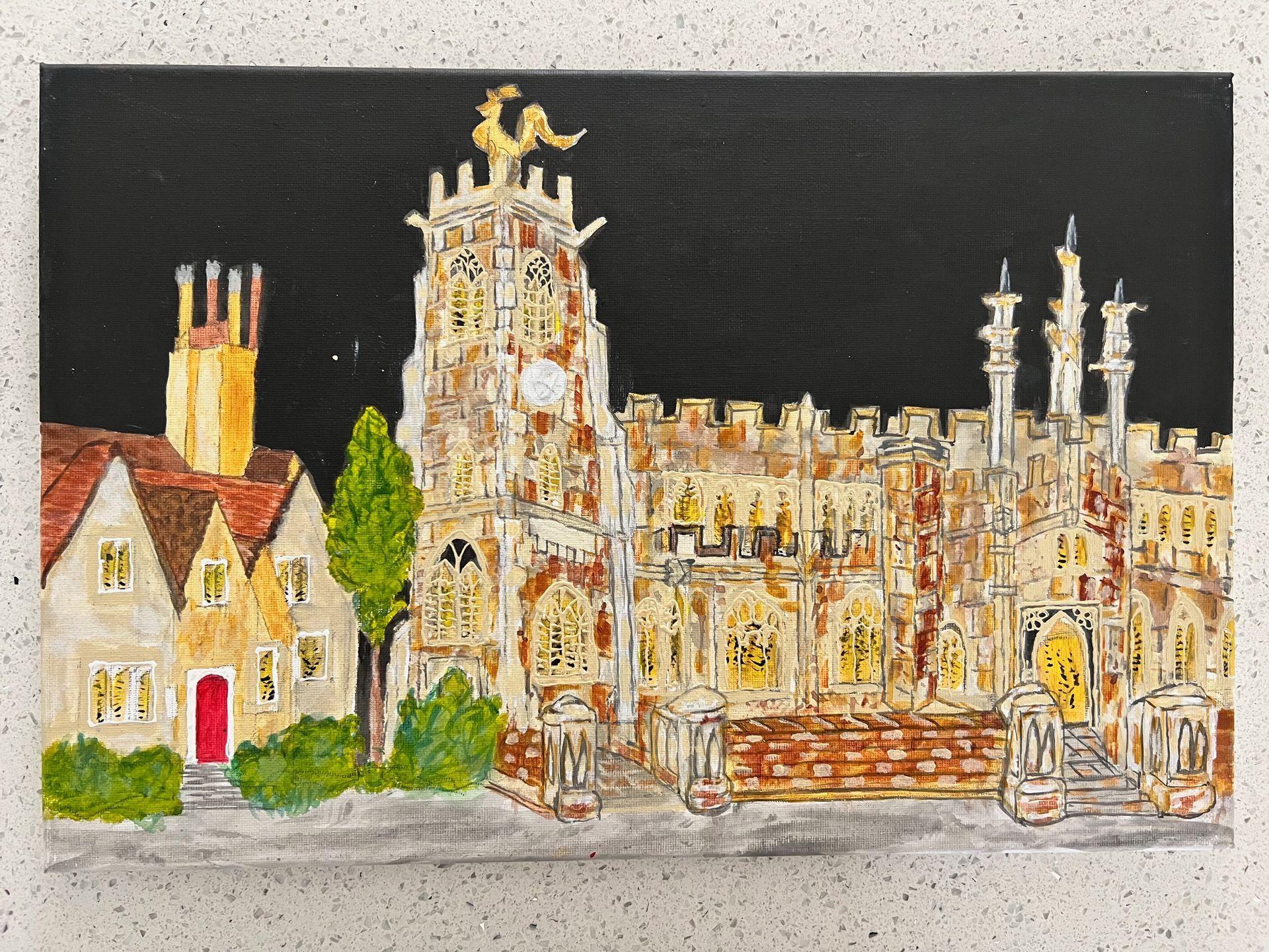 Church and buildings at night, with illuminated windows and a black sky.