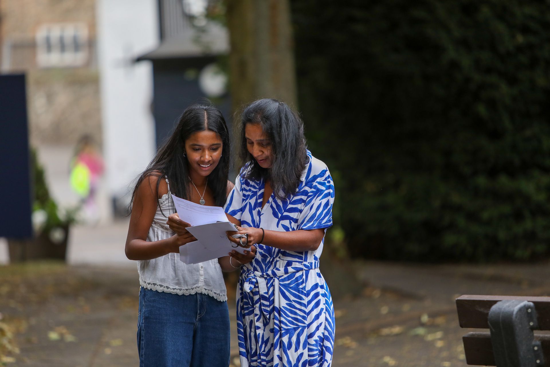 A woman and a girl are looking at a piece of paper.