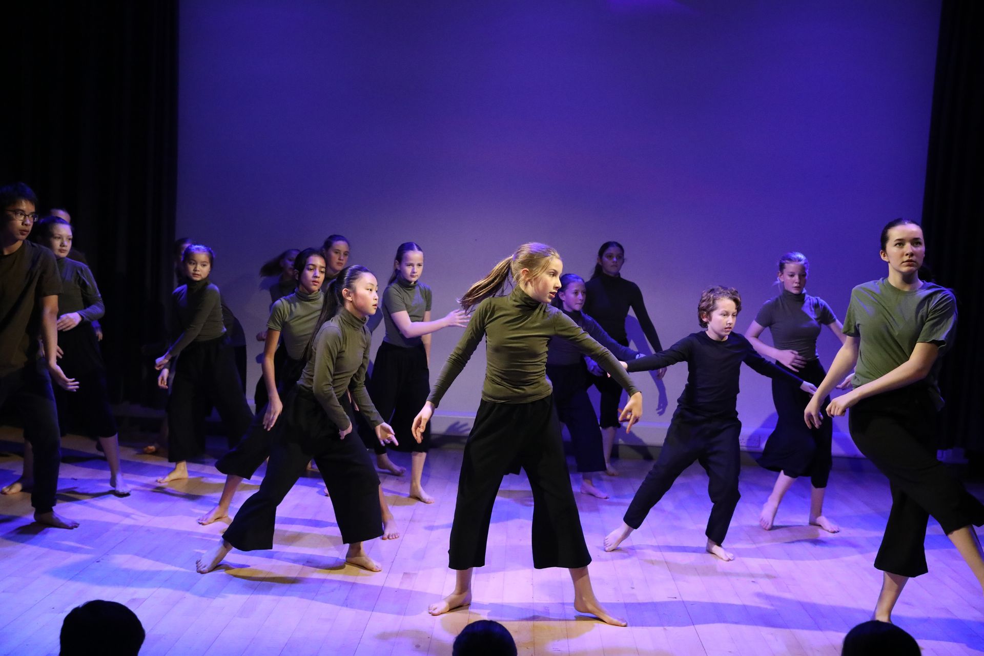 A group of young people are dancing on a stage.