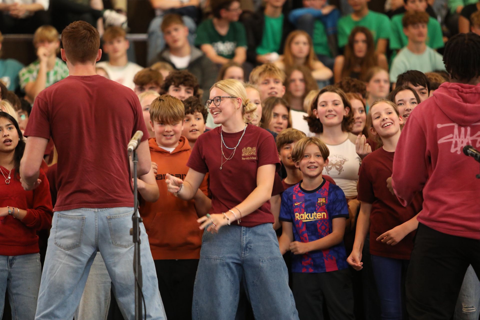 A group of people are standing in front of a microphone in front of a crowd.