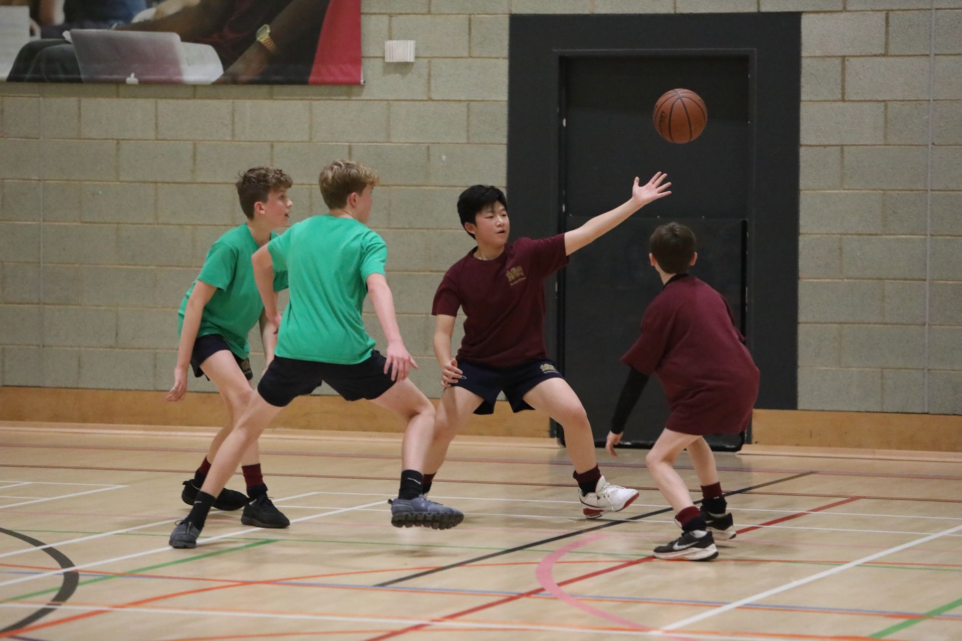 A group of young boys are playing basketball on a court.