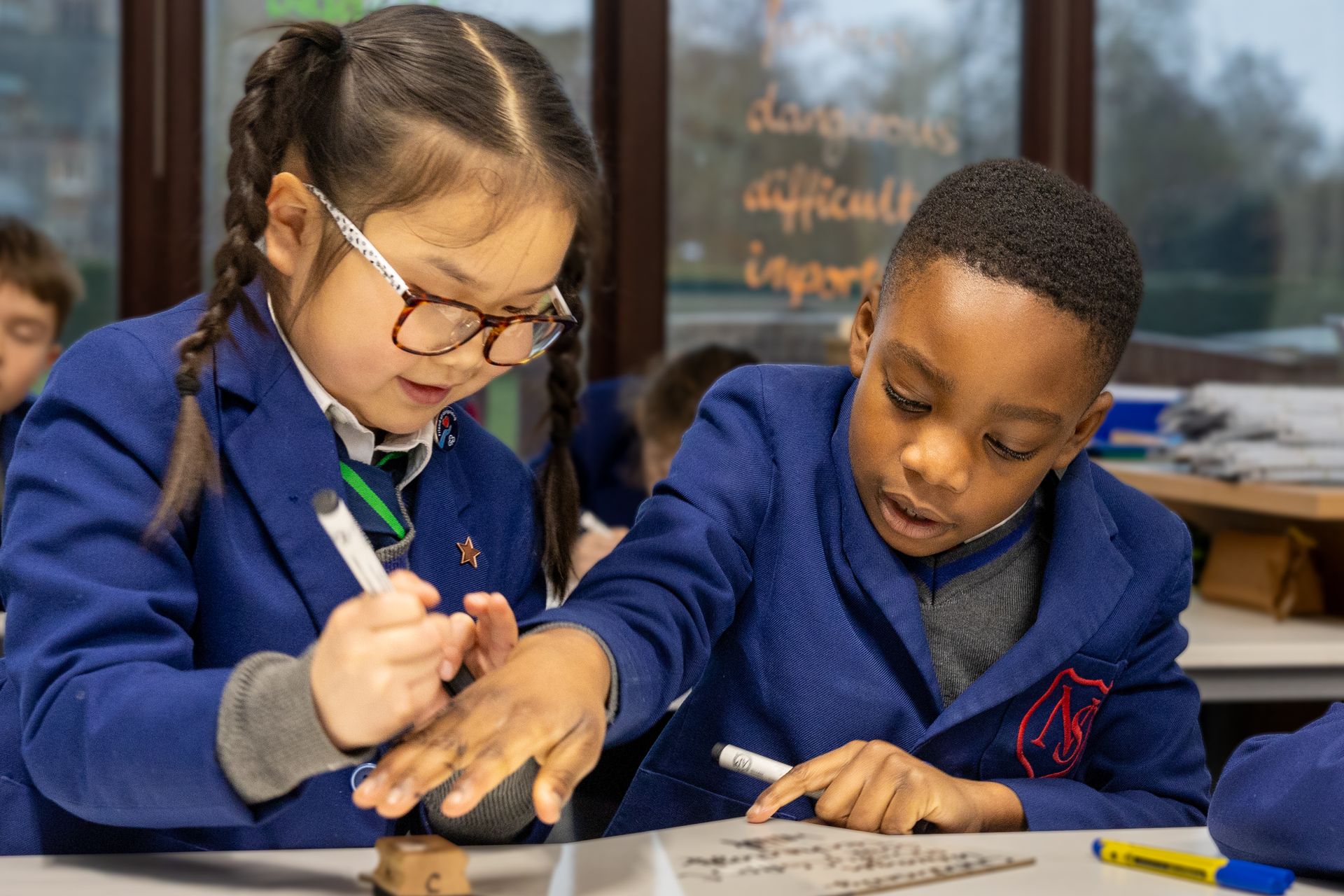 Two young boys are playing with wooden blocks in a garden.