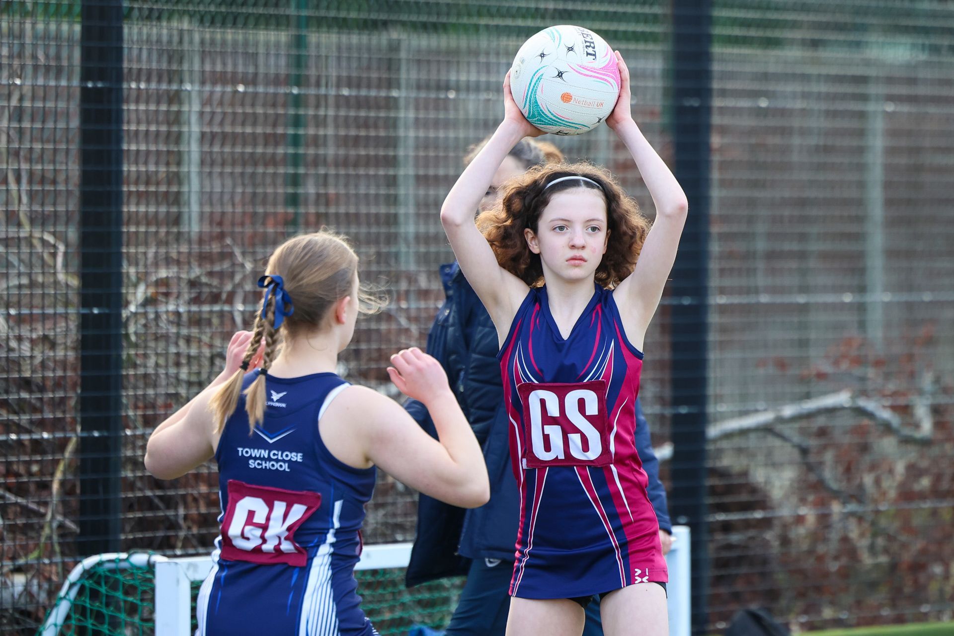 A group of women are playing a game of netball on a court.