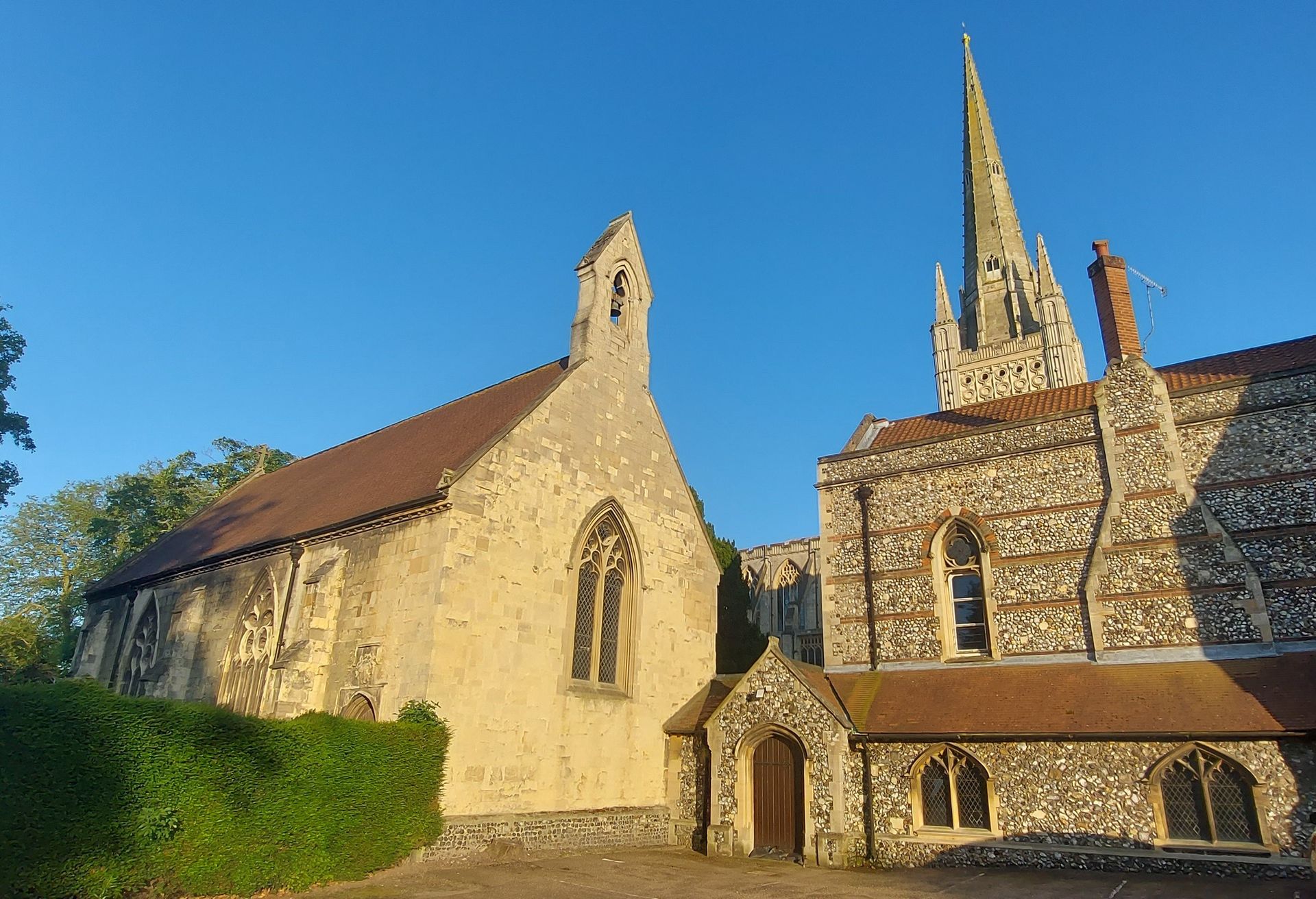 A church with a steeple and a smaller church next to it.