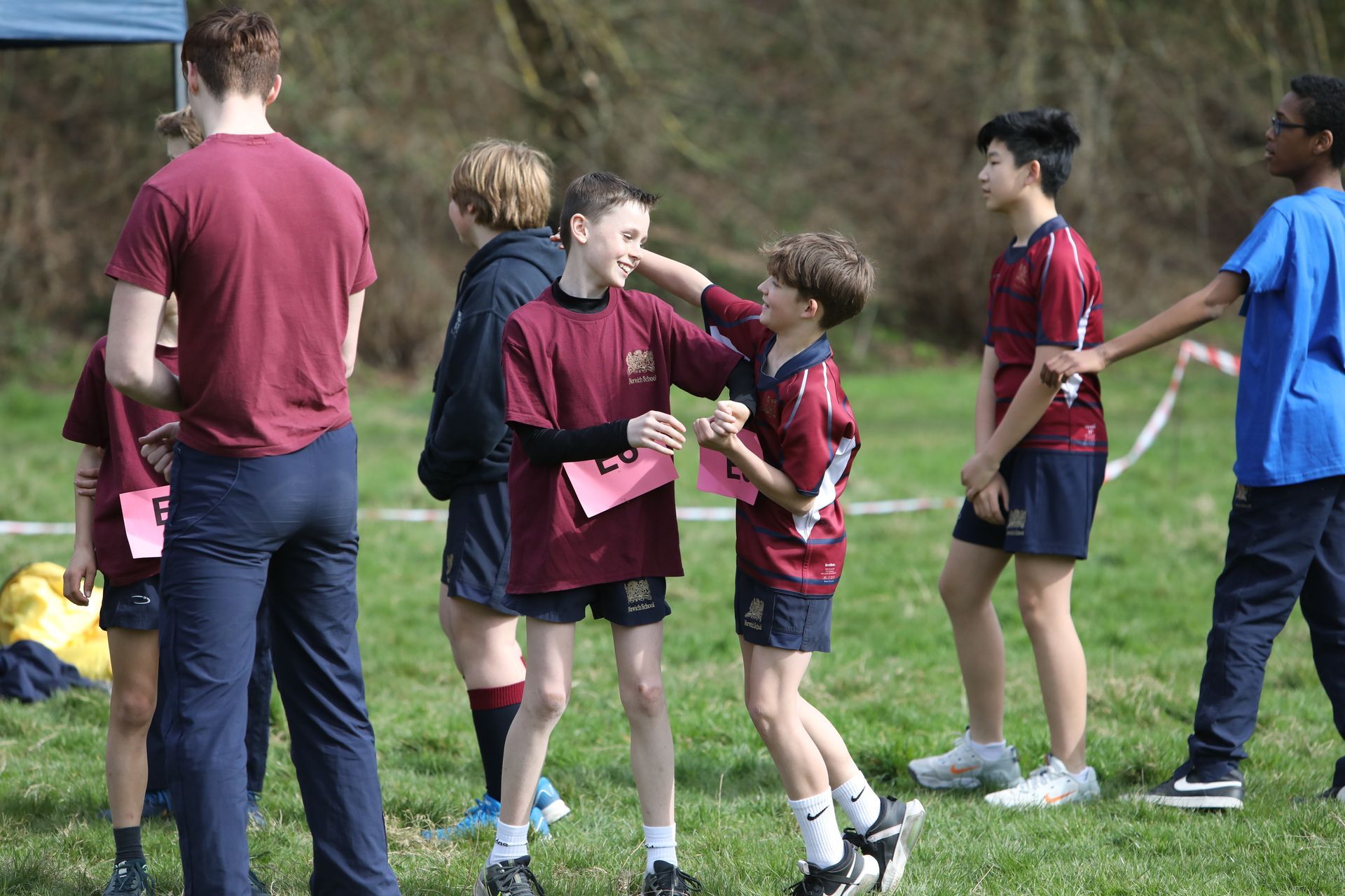 A group of young boys are standing on a grassy field.