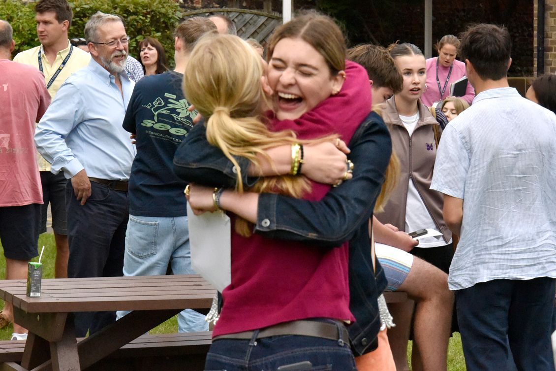 A woman is hugging another woman in front of a crowd of people