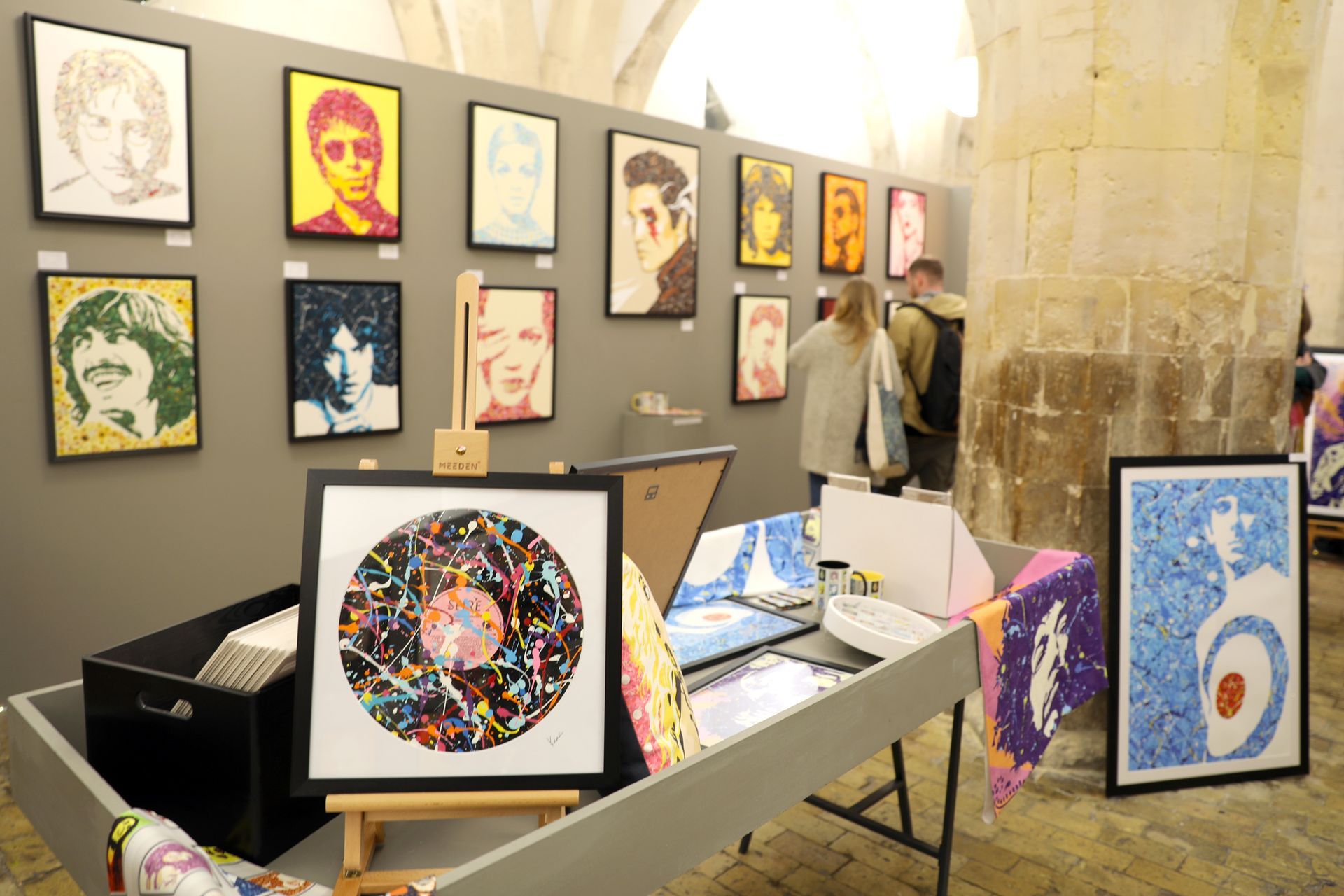 A room filled with paintings and a table with a record on it.