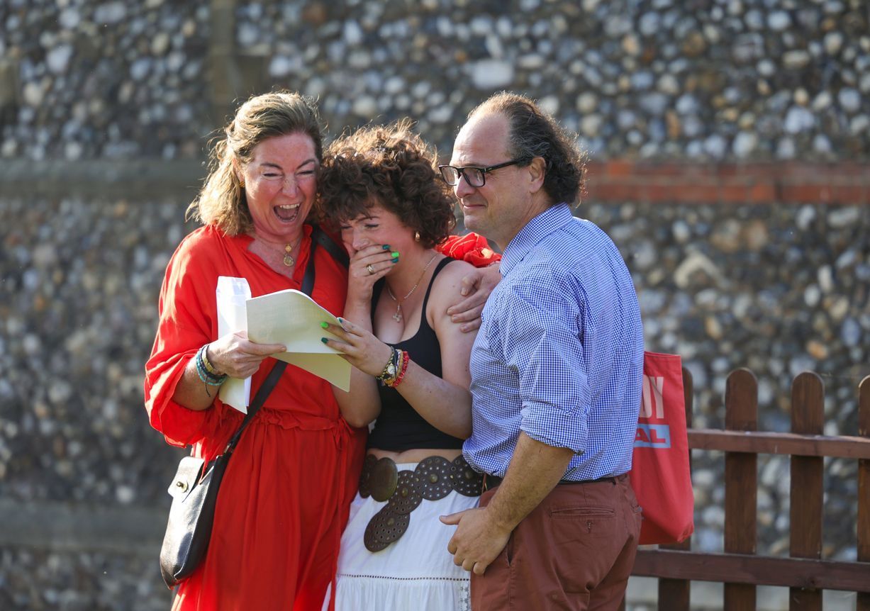 A large building with a red roof and trees in front of it.