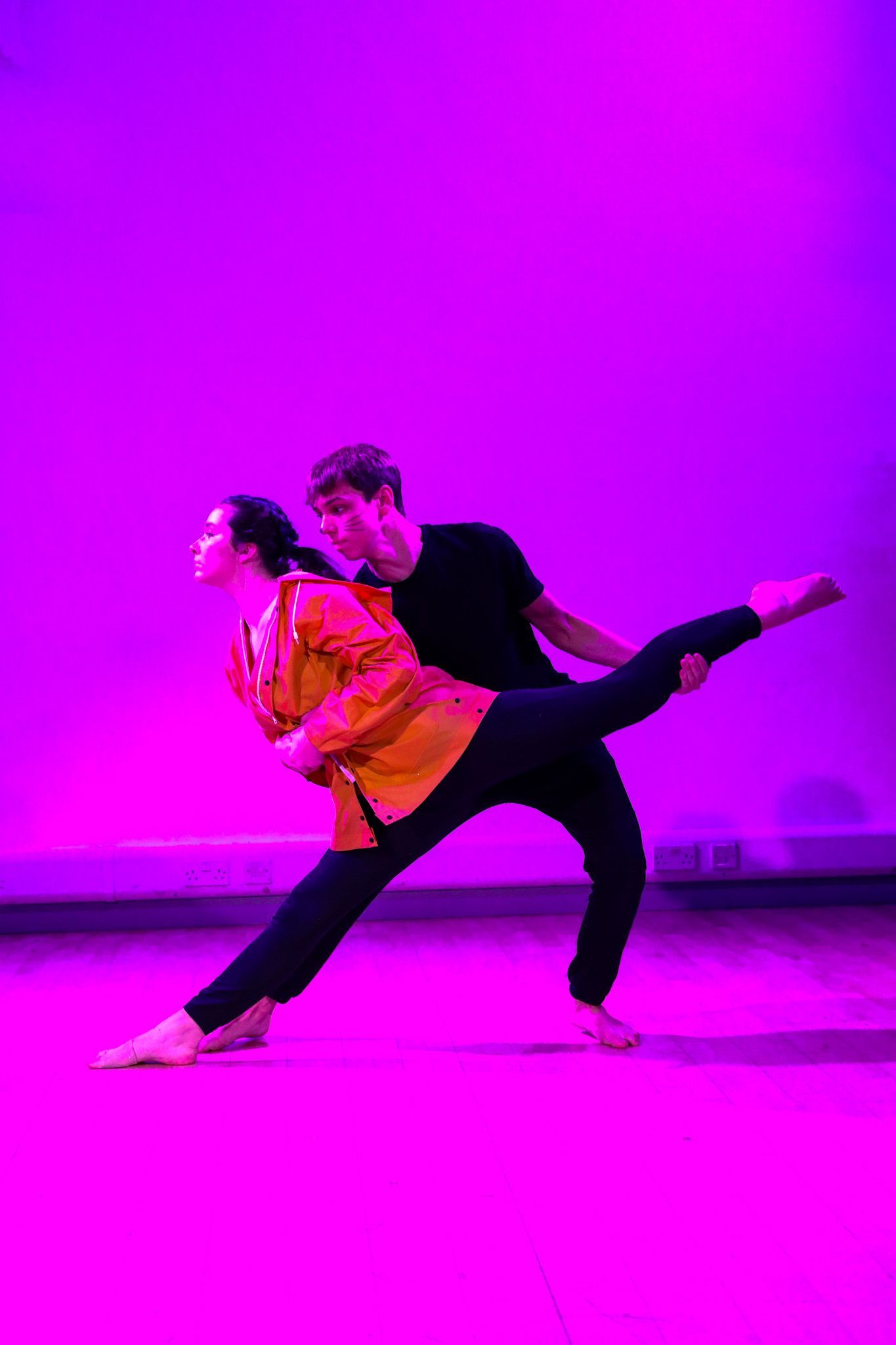 A man is holding a woman in his arms while they dance on a stage.