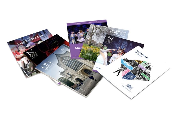 A group of brochures are stacked on top of each other on a white background.