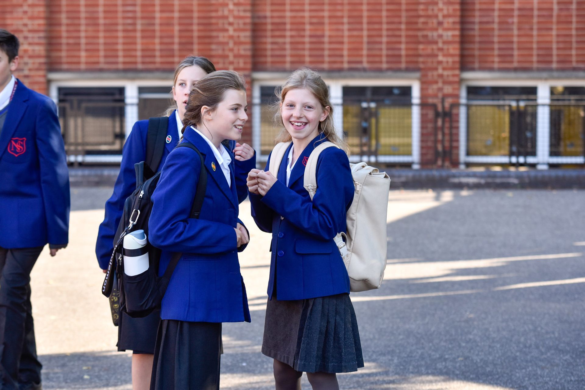 A group of children in school uniforms are sitting around a table.