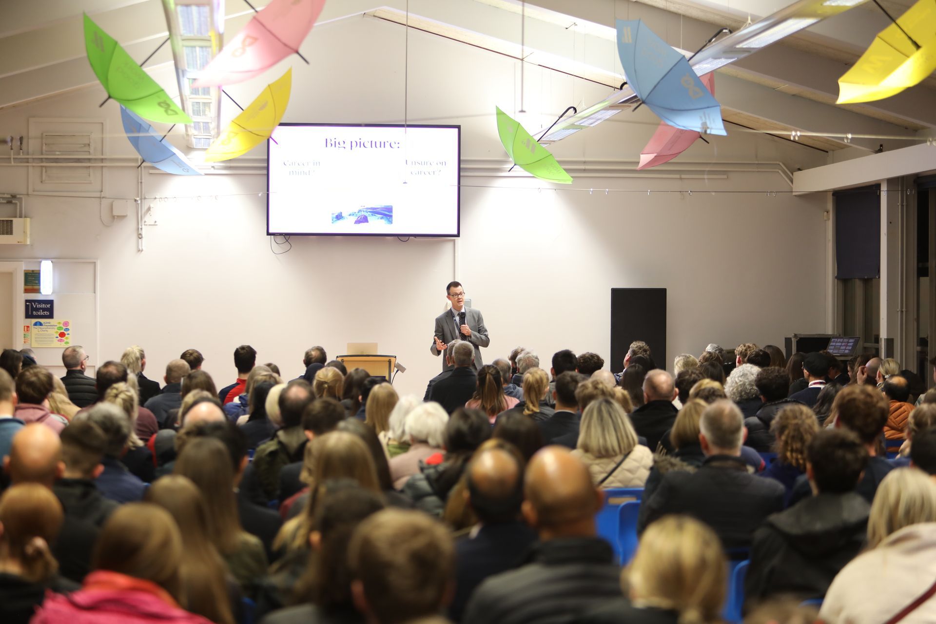 A man is giving a presentation to a large group of people