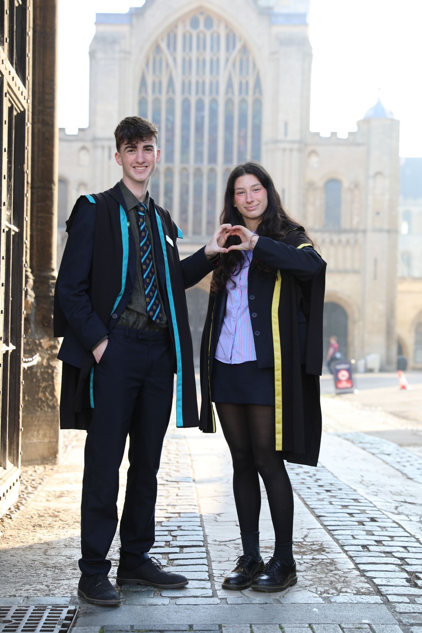 Two pupils sitting at a table in a classroom working on a project.