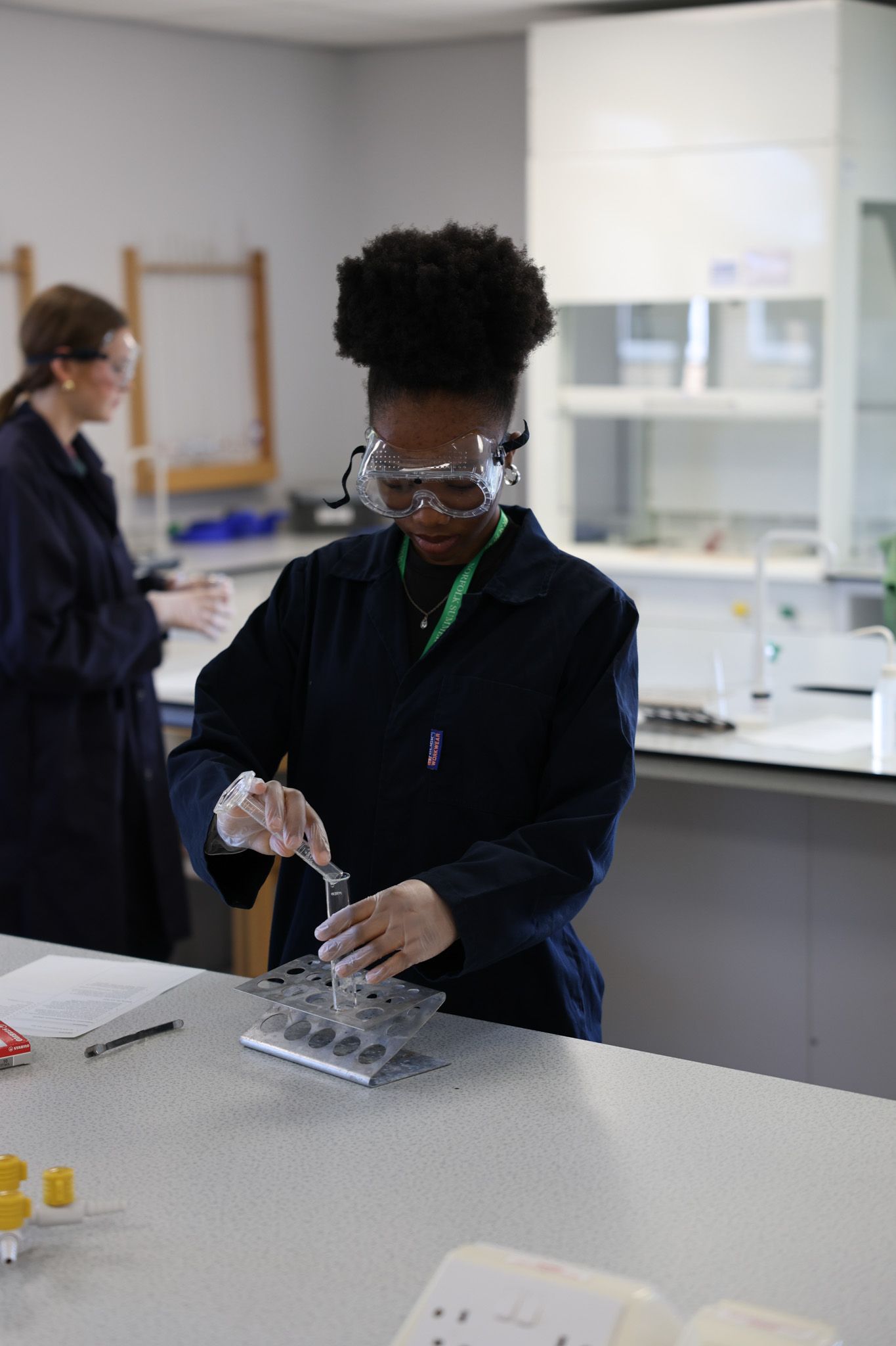 A large group of people are standing in front of a brick building.