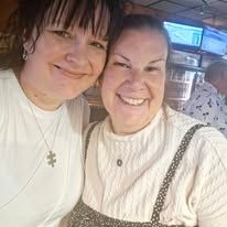 Two women are posing for a picture together in a restaurant.
