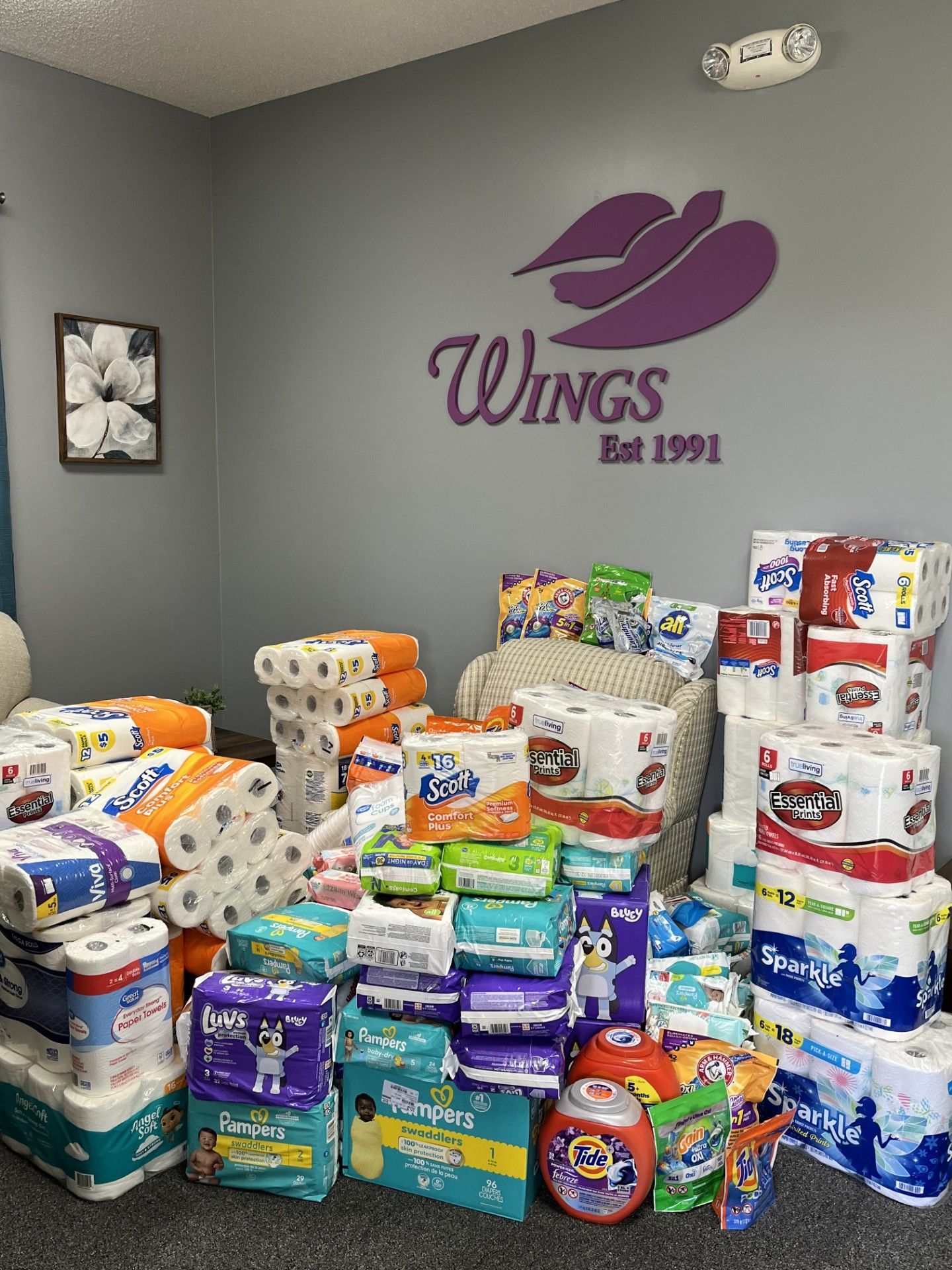 A pile of donated paper products in an office with a purple