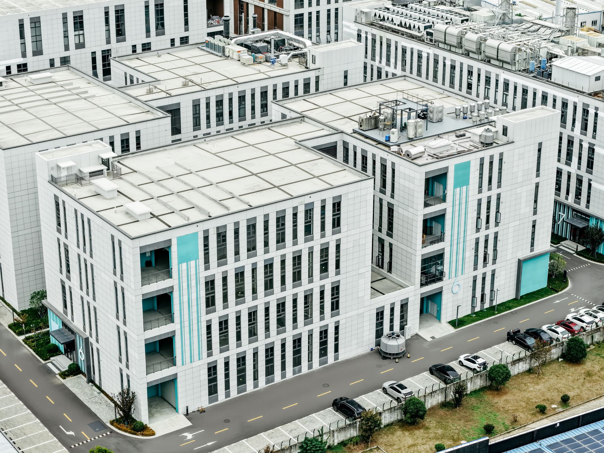 White and light blue industrial buildings with many windows.