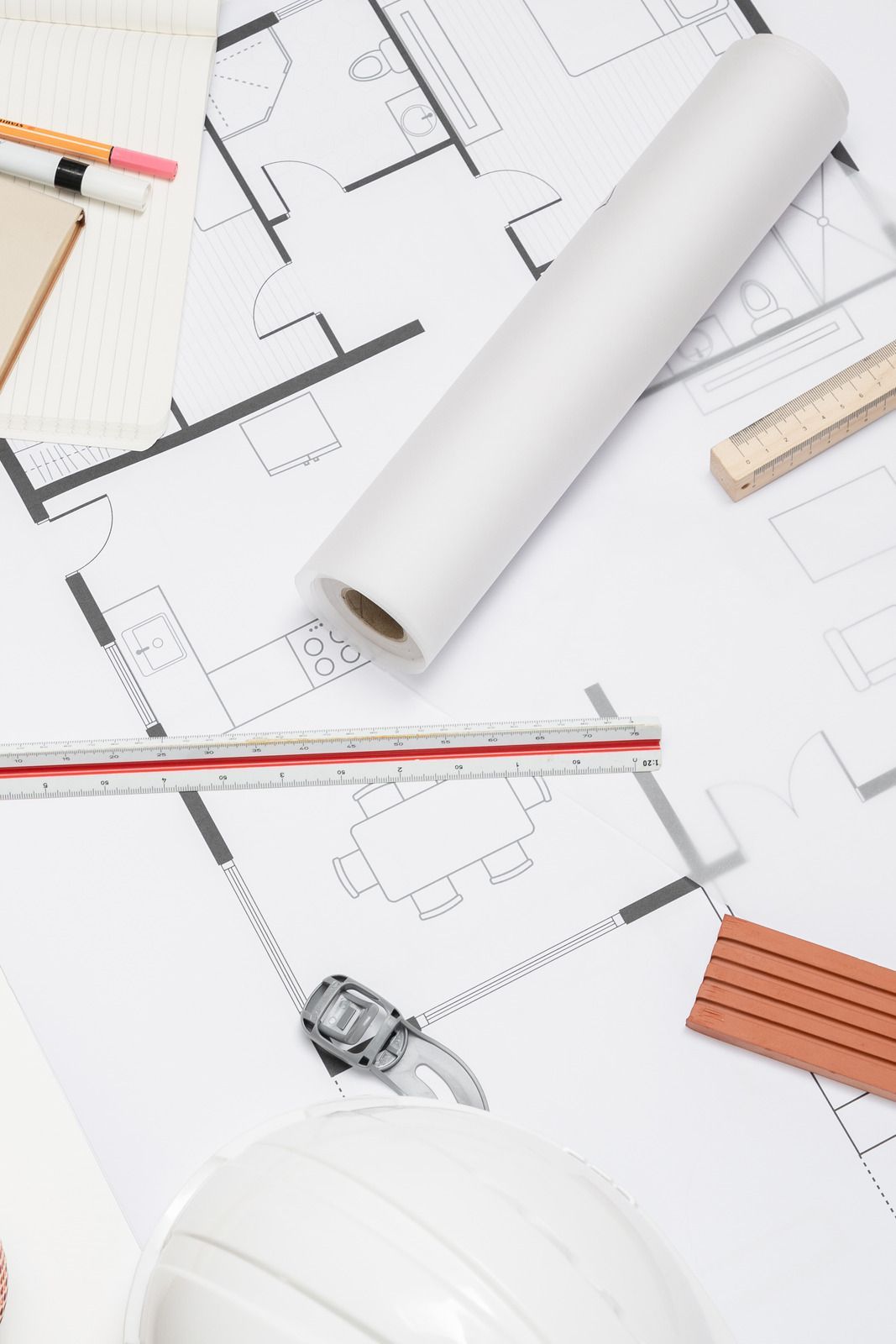 Hands point to charts and data on a table during a collaborative work meeting with a tablet, mug, and notes.