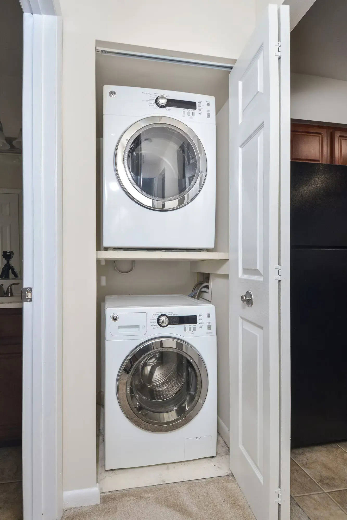 Stacked washer and dryer in a narrow laundry closet.