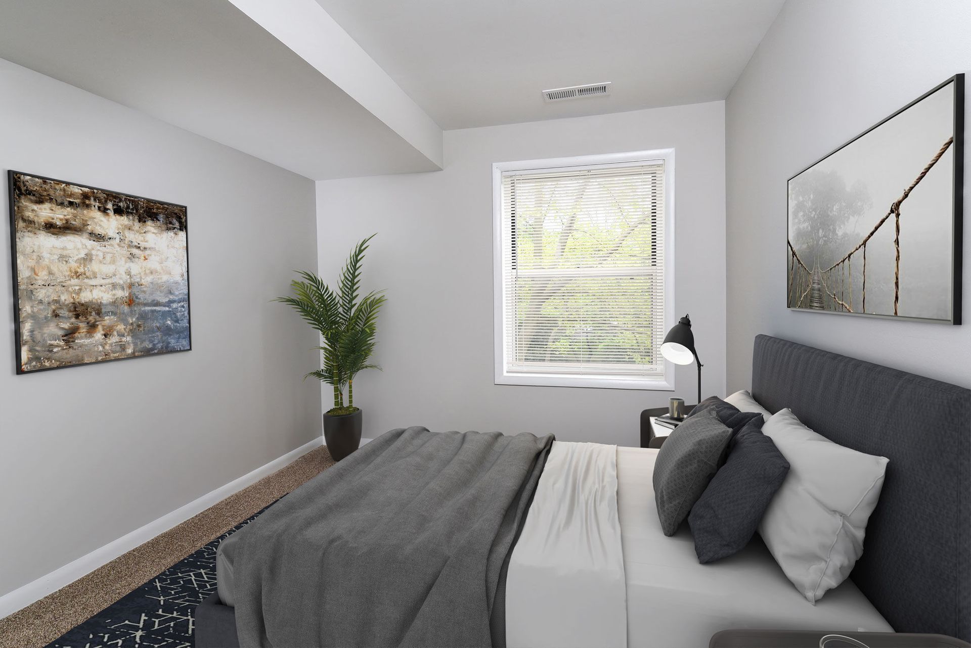 Bedroom in a modern apartment with a bed, nightstand, lamp, window, and wall art.