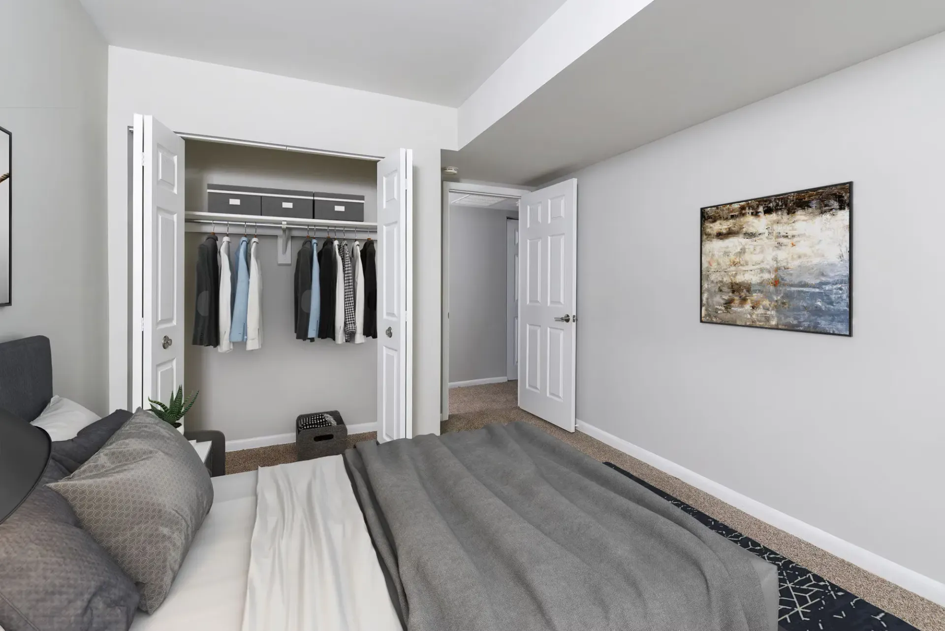 Bedroom with a bed in foreground and an open closet containing clothes and storage bins.