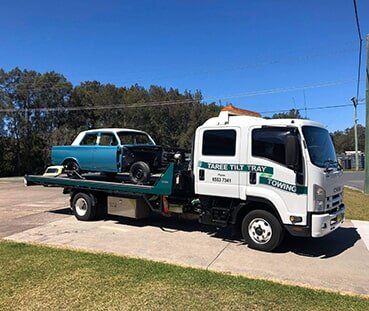 Truck Carrying Blue Car — Emergency Towing in Taree, NSW