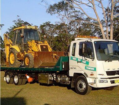Truck Carrying Mini Excavator — Emergency Towing in Taree, NSW