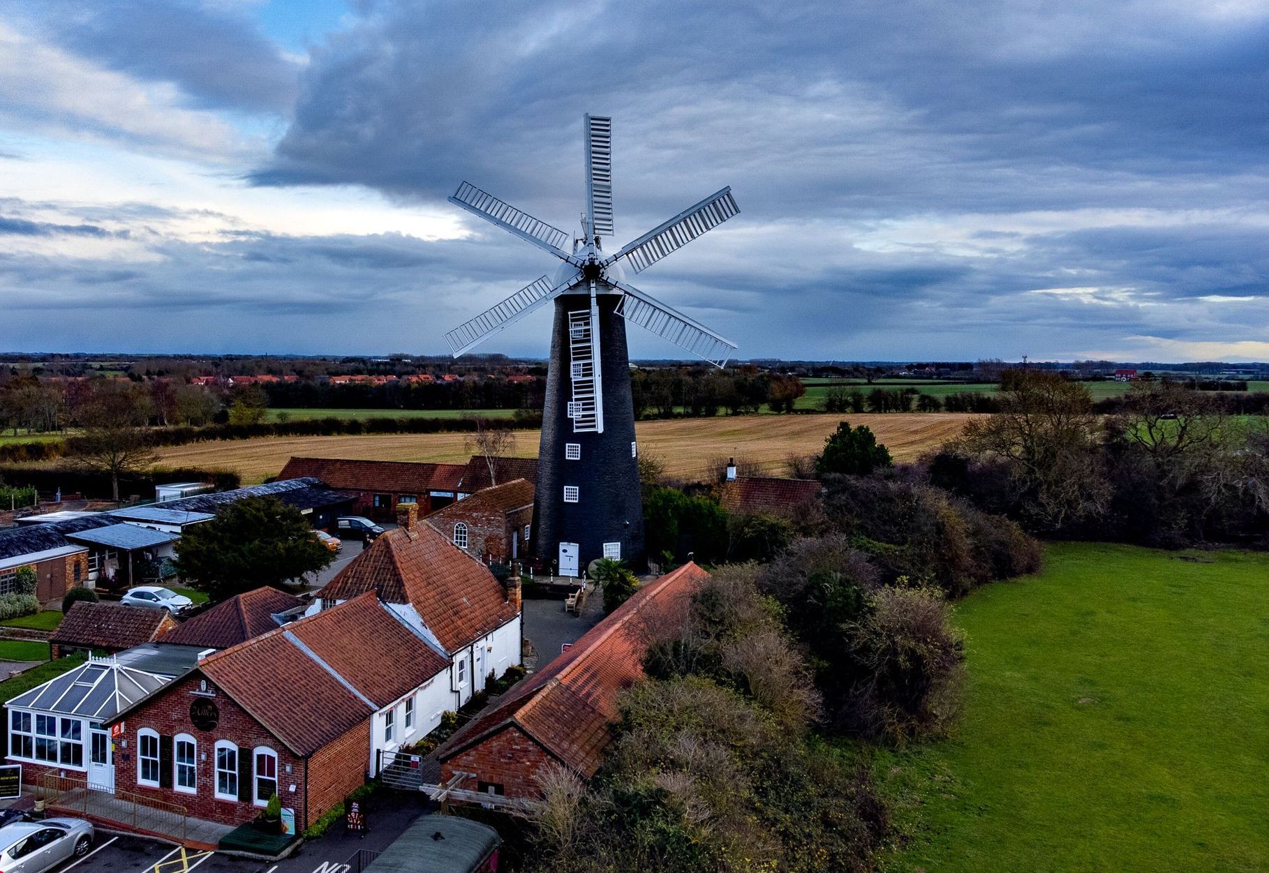 An aerial view of a windmill in the middle of a field.