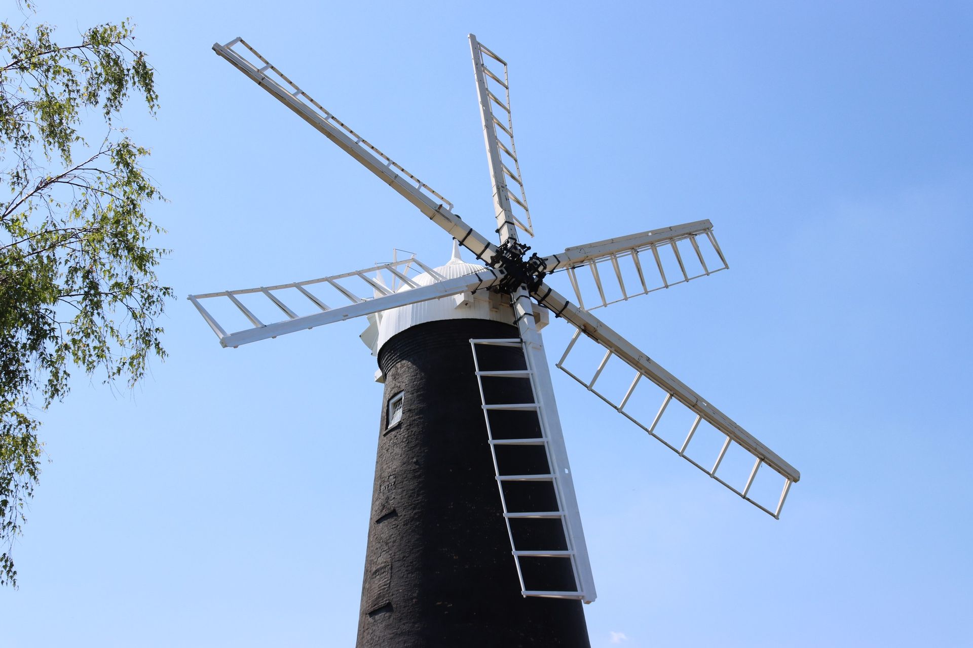 A windmill with a blue sky in the background