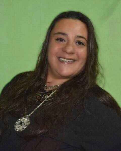 Abuelo sonriente abrazado por dos nietas sonrientes.