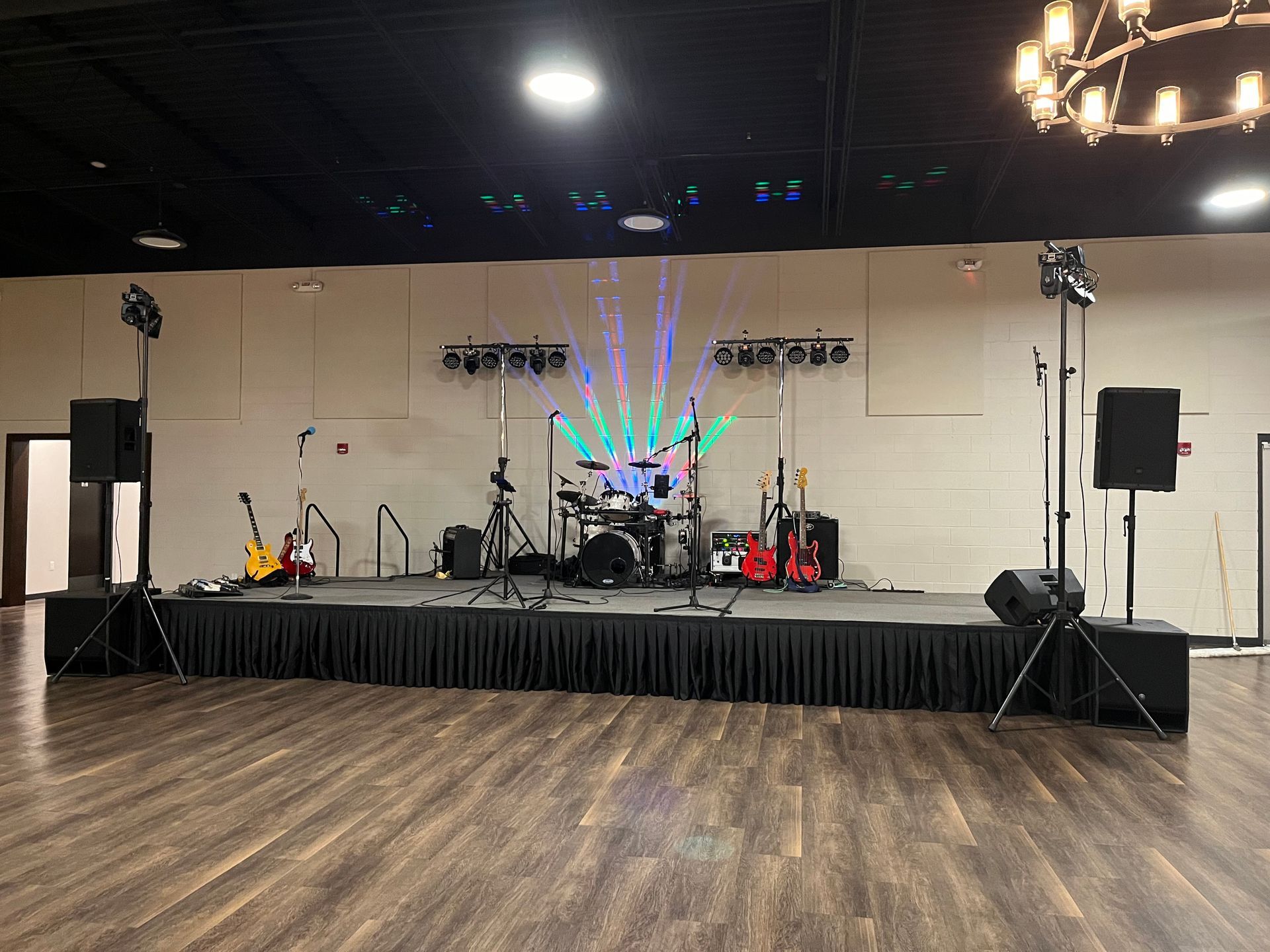 A large empty room with a stage set up for a band.