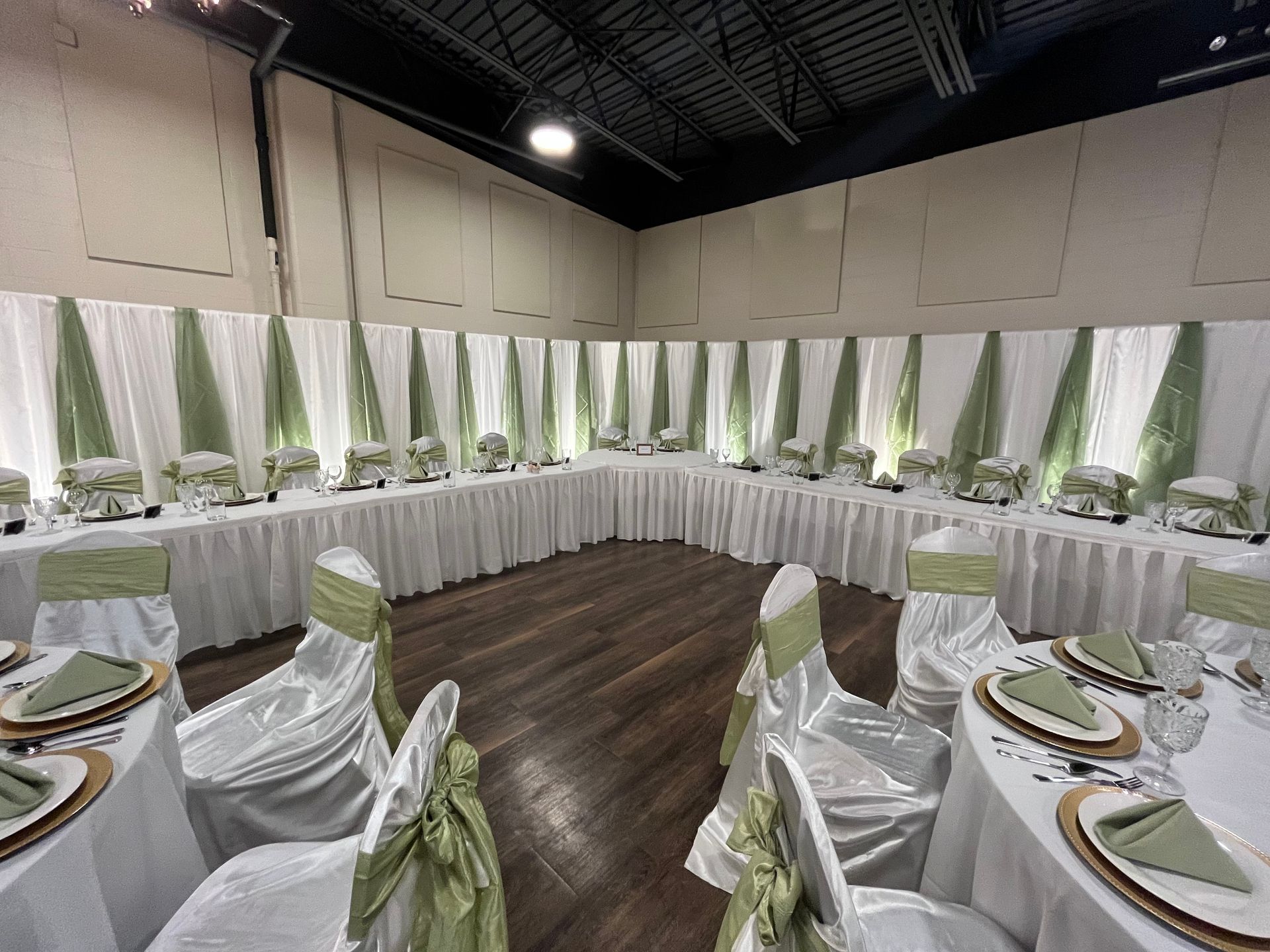A room with tables and chairs set up for a wedding reception