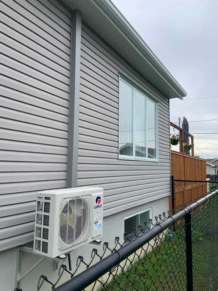 Une maison avec une clôture et un ventilateur sur le côté.