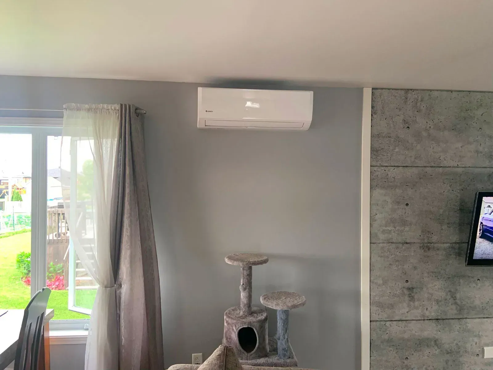 Un salon avec un arbre à chat et une télévision.