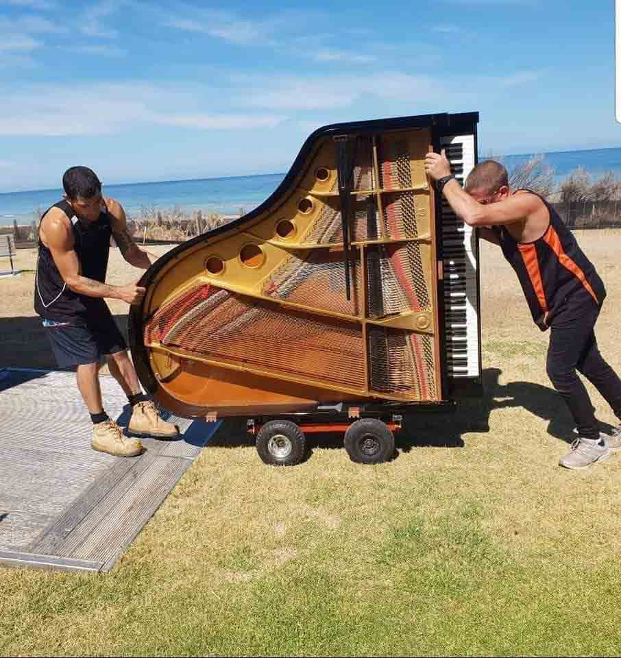 two workers moving piano